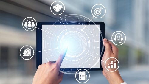 Main tenant une tablette avec interface digitale et icônes liées à l’organisation et au support client