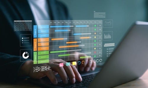 Bloc-notes indiquant les livrables clés d’un projet, posé à côté d’outils de travail.