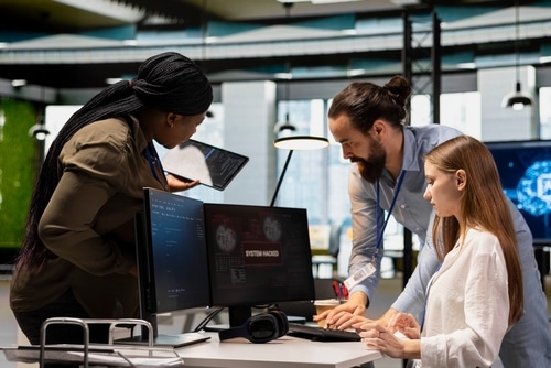 plusieurs développeurs réunis autour d’un tableau de gestion de projet numérique
